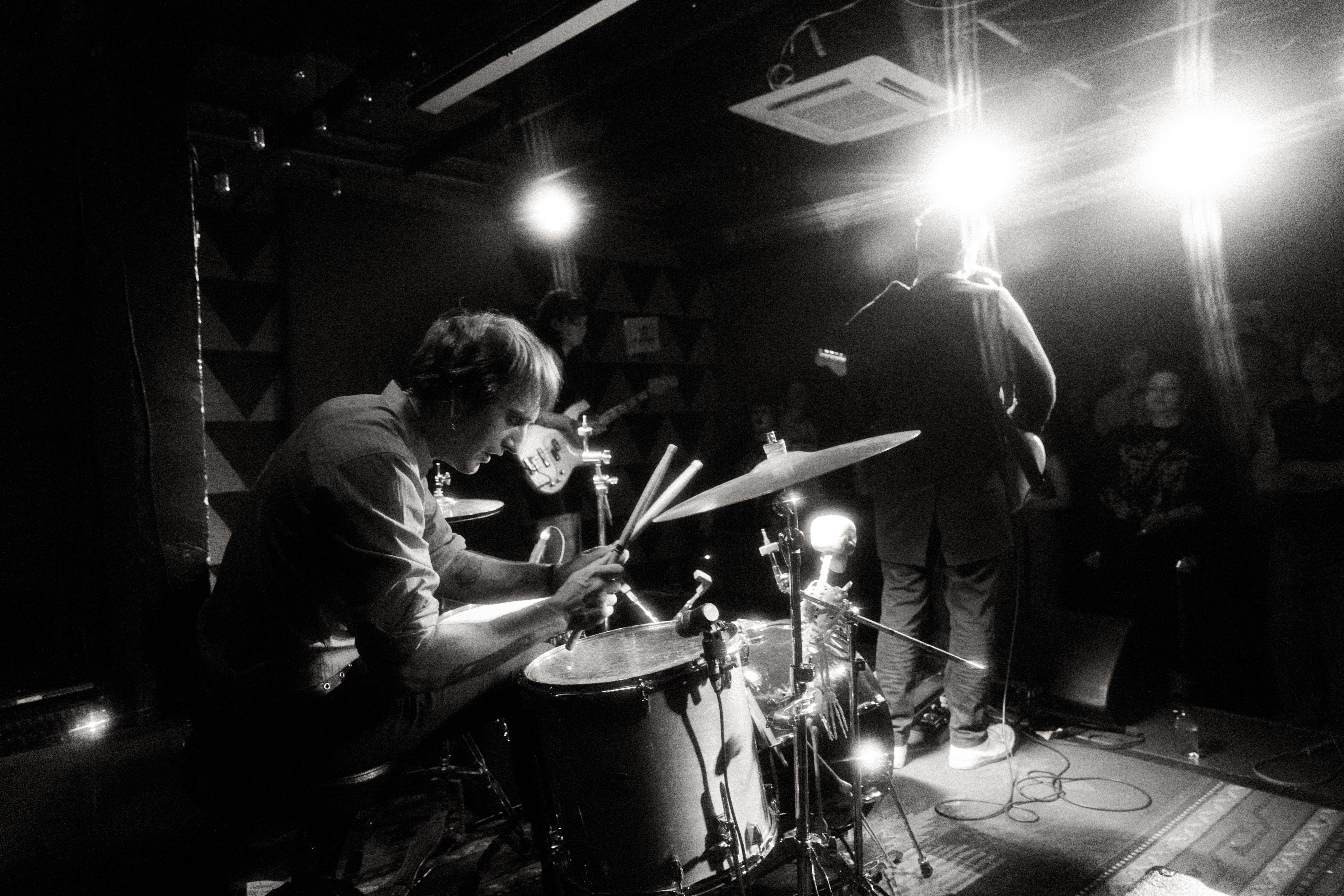 Etiquette drummer and band on stage during a live set